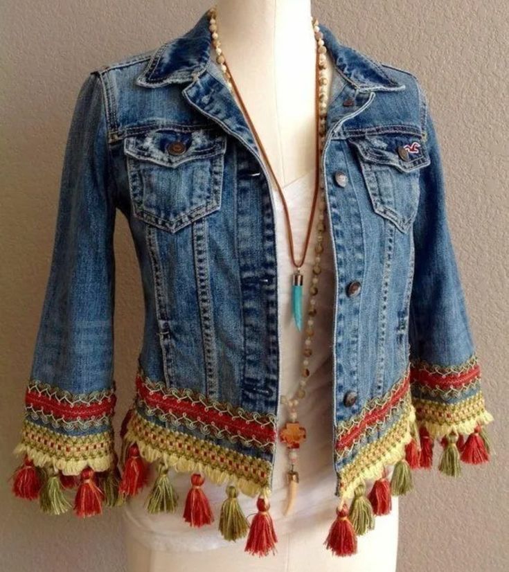 a white mannequin wearing a jean jacket with tassels and beads on it