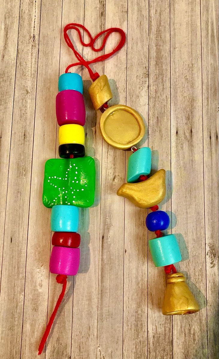 an assortment of colorful wooden toys sitting on top of a wooden floor next to a string