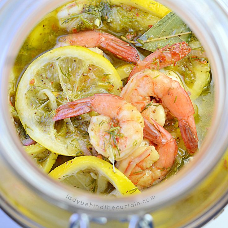 a glass jar filled with lemon and shrimp