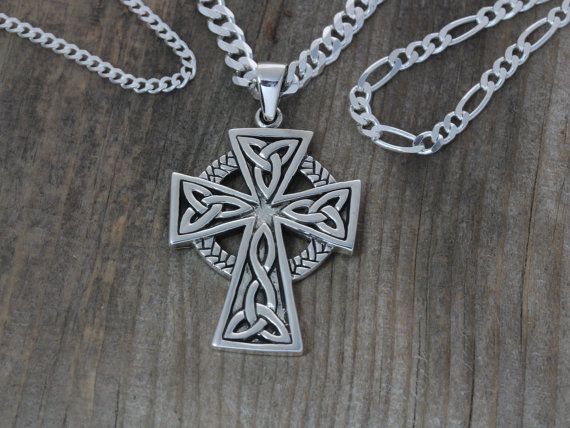 a celtic cross necklace on a wooden surface