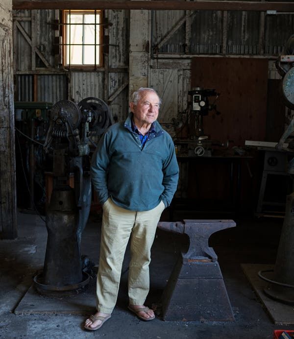 an older man standing in front of a machine