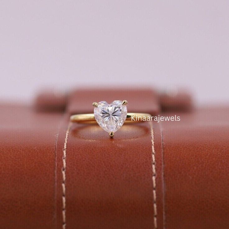 a gold ring with a heart shaped diamond