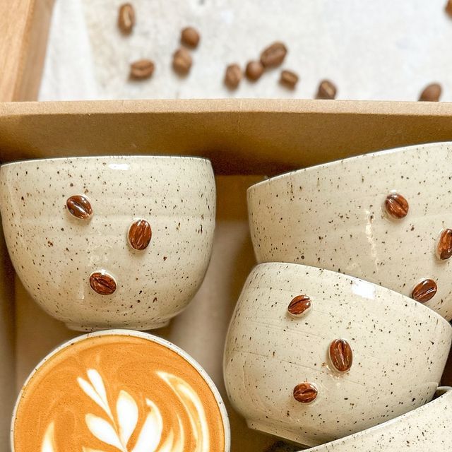 coffee cups and saucers in a box with nuts