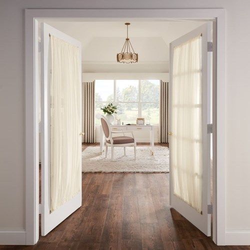 an open door leading to a dining room with a white table and chairs in it