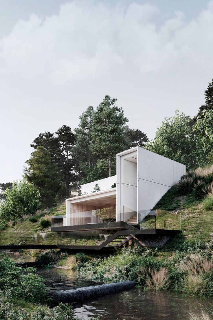 the house is built on top of a hill with trees around it and water below