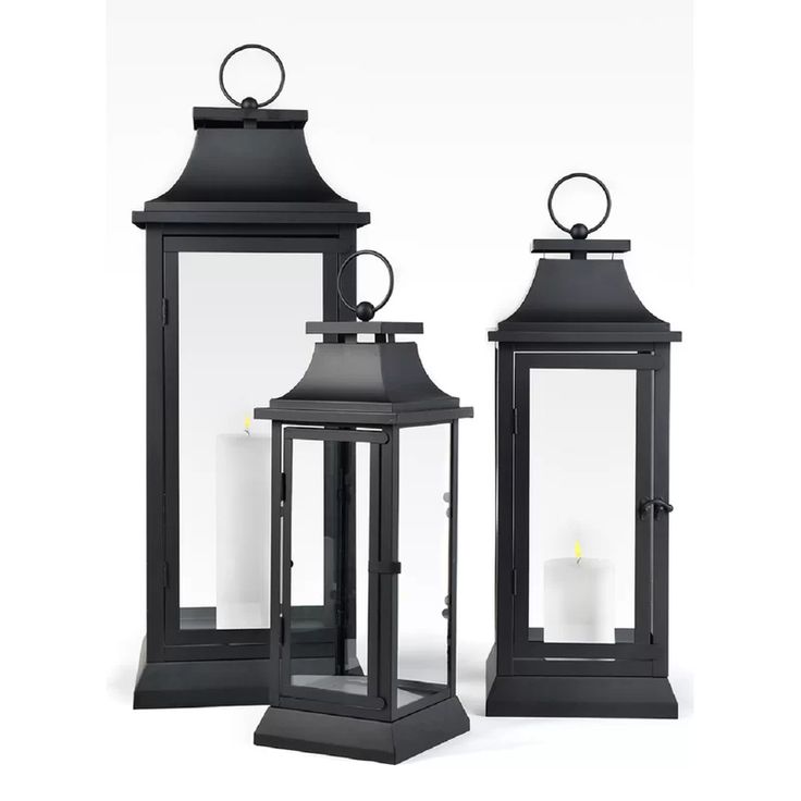 three black lanterns with lit candles in them on a white background, one is open and the other closed