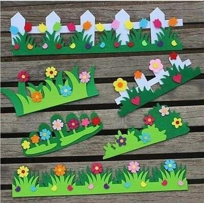 paper flowers and grass cut out on wooden boards