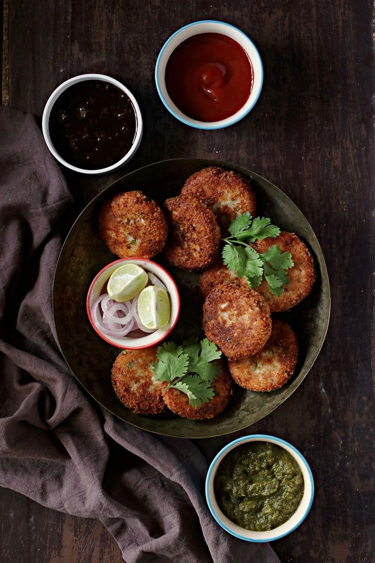 some food is sitting on a plate with sauces and condiments around it