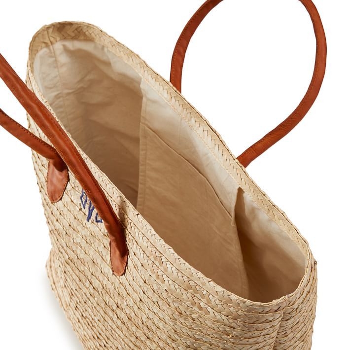 Handmade in Indonesia from woven palm leaf, this spacious tote is the perfect accessory for warm summer days and nights. Easy to carry with leather handles and roomy enough for all your beach essentials, the Palm Leaf Tote features a soft linen lining and an interior pocket to keep all your little essentials safe. • 20"w x 8.5"d x 14"h • Woven from natural palm leaf with a soft linen lining and leather handles. Please note: The embroidered monogram shown in the pictures is only for illustrative Summer Beach Bag With Rolled Handles, Vacation Beach Tote Bag With Rolled Handles, Everyday Summer Beach Bag With Rolled Handles, Woven Leather Beach Bag For Everyday Use, Natural Woven Double Handle Beach Bag, Vacation Beach Bag With Rolled Double Handles, Casual Beige Straw Bag With Rolled Handles, Woven Palm Leaf Beach Bag For Travel, Travel Beach Bag Woven From Palm Leaf