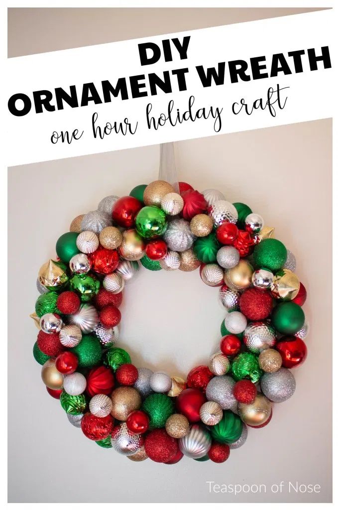 an ornament wreath hanging on the wall with ornaments around it and text overlay that reads diy ornament wreath one from holiday craft