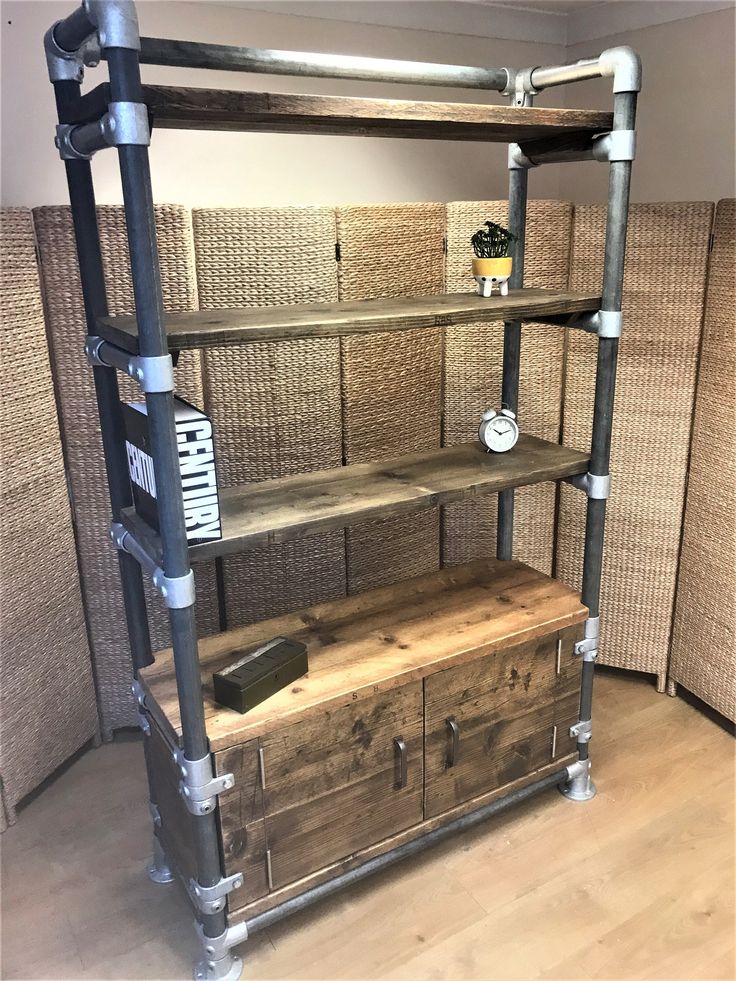 an industrial style shelving unit with drawers and pipes on the bottom, in a room