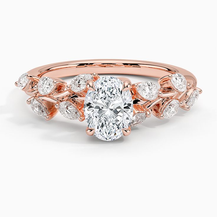 a rose gold engagement ring with an oval diamond center and leaves on the band, set in