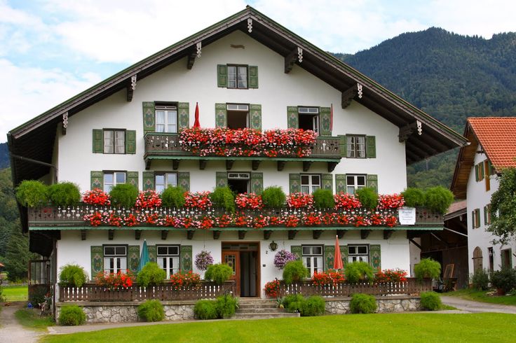 a large white house with flowers on the balconies