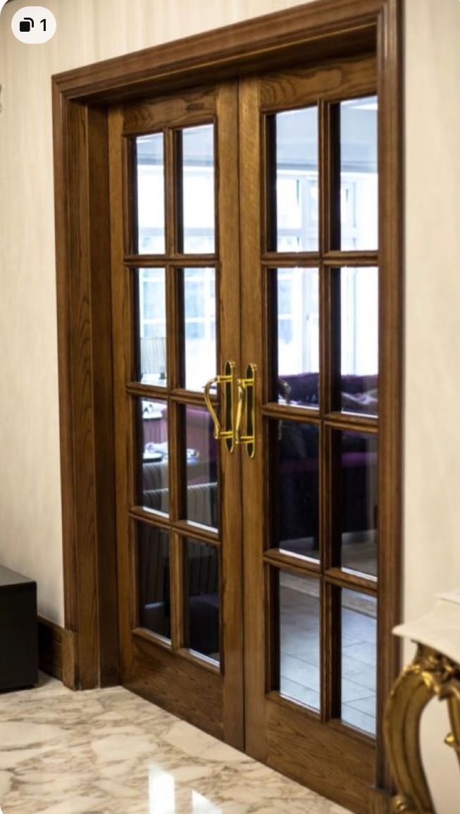 an open wooden door in a room with marble flooring