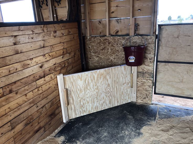 the inside of a horse trailer with wood paneling on the walls and doors open