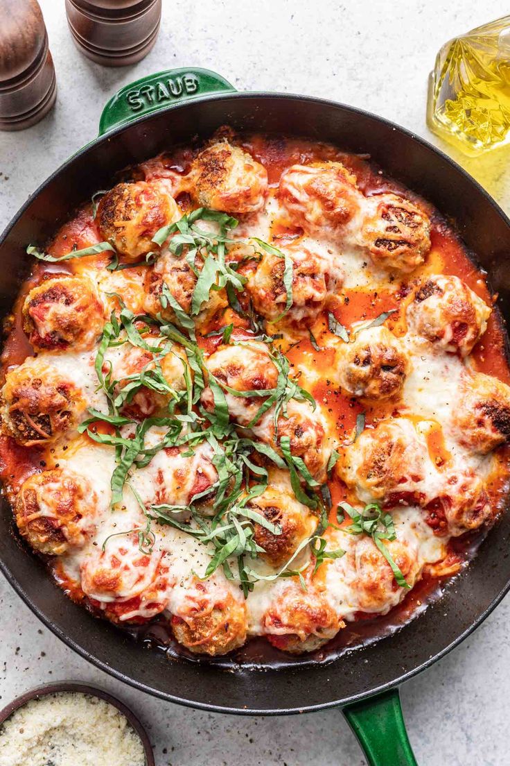 a pizza sitting in a pan on top of a table next to glasses and utensils