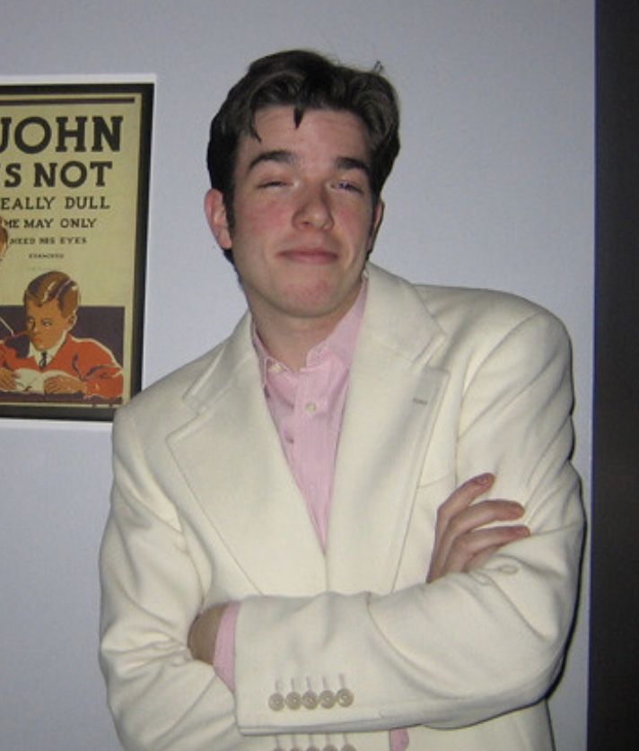 a man in a white suit and pink shirt