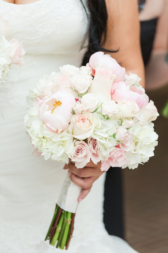 a bride holding a bouquet of white and pink flowers