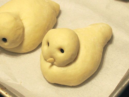 two doughnuts shaped like animals on a baking sheet