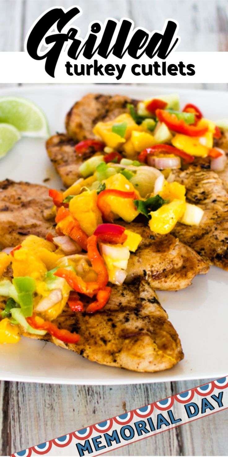 grilled turkey cutlets with fruit and vegetables on a white plate next to lime wedges