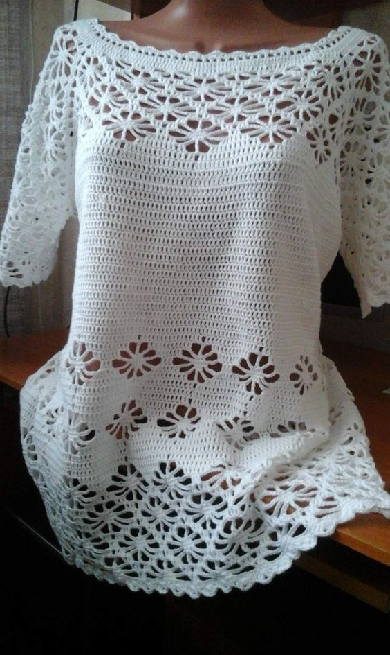 a white crocheted top is shown on a mannequin