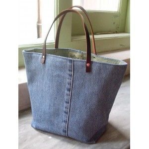 a denim tote bag sitting on top of a wooden floor next to a window