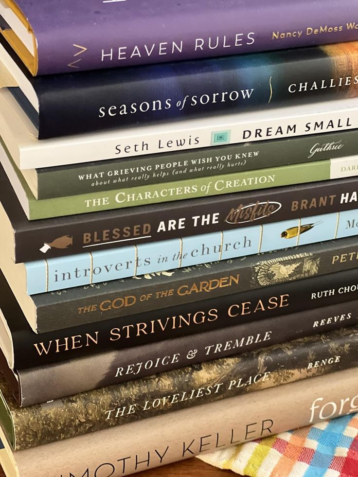 a stack of books sitting on top of a wooden table