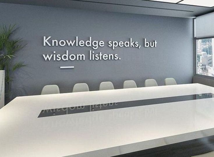 a conference room with a large white table and chairs in front of a wall that reads, knowledge speaks, but wisdom listens