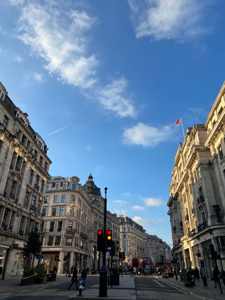 an empty street with buildings on both sides and a red traffic light in the middle