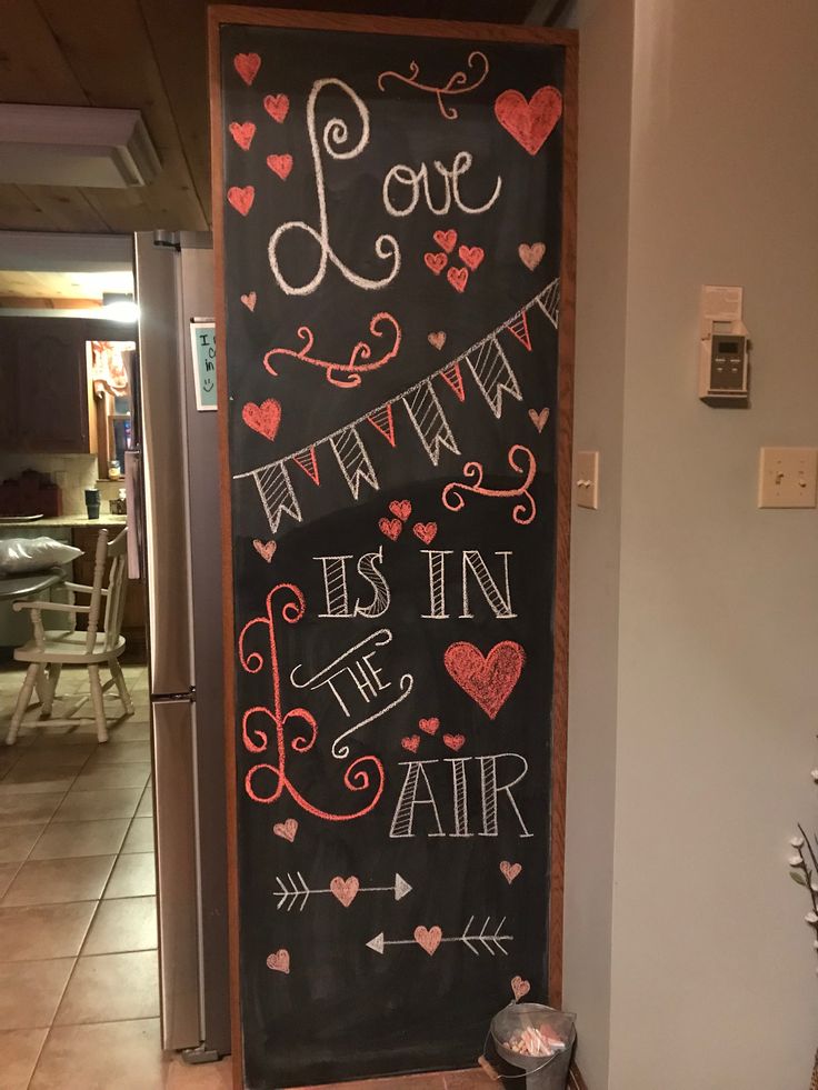 a chalkboard with the words love is in the air written on it