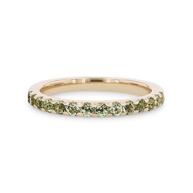 a yellow gold band with green stones