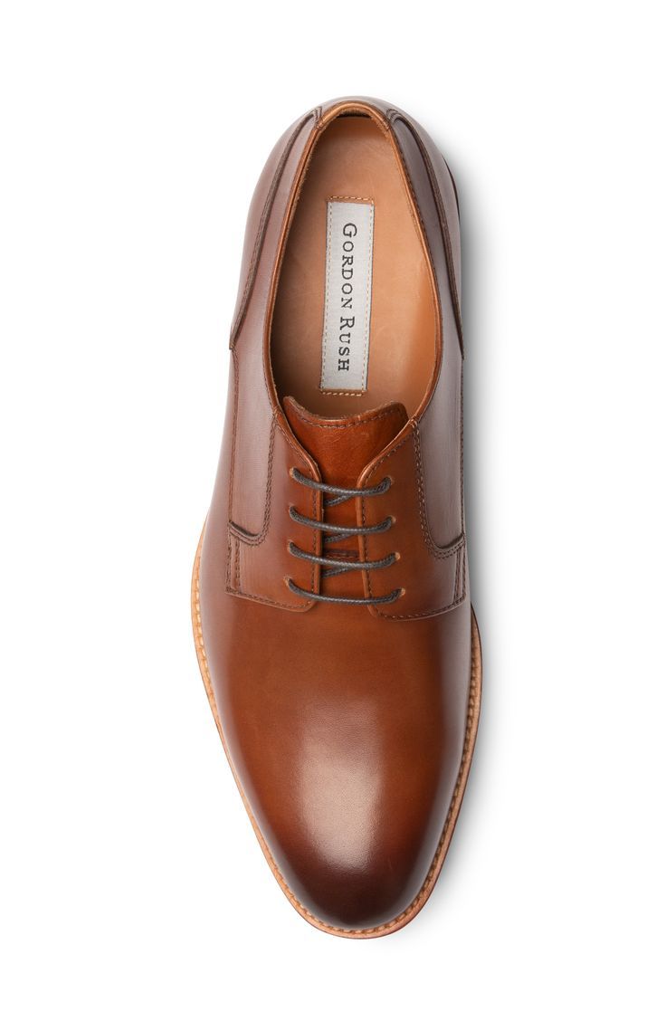 Traditional oxford with a round chisel toe. Where most oxfords use one continuous cut of leather, we separated the upper into different panels to create more points of visual interest. The toe box has a lower profile, and we opted for a natural leather sole to keep things laid-back. The result is a sleek, pared-down dress shoe that’s far from formal. #dressshoe #summerstyle #springshoe #oxford #leathershoe #italianinspo #gordonrush Leather Plain Toe Oxfords For Semi-formal Occasions, Formal Goodyear Welted Lace-up Leather Shoes, Modern Leather Oxfords With Leather Lining, Semi-formal Leather Oxfords With Leather Footbed, Modern Leather Oxfords With Brogue Detailing, Leather Moc Toe Derby For Work, Masculine Moc Toe Leather Shoes For Derby, Semi-formal Leather Oxfords With Branded Insole, Business Casual Leather Oxfords With Leather Lining