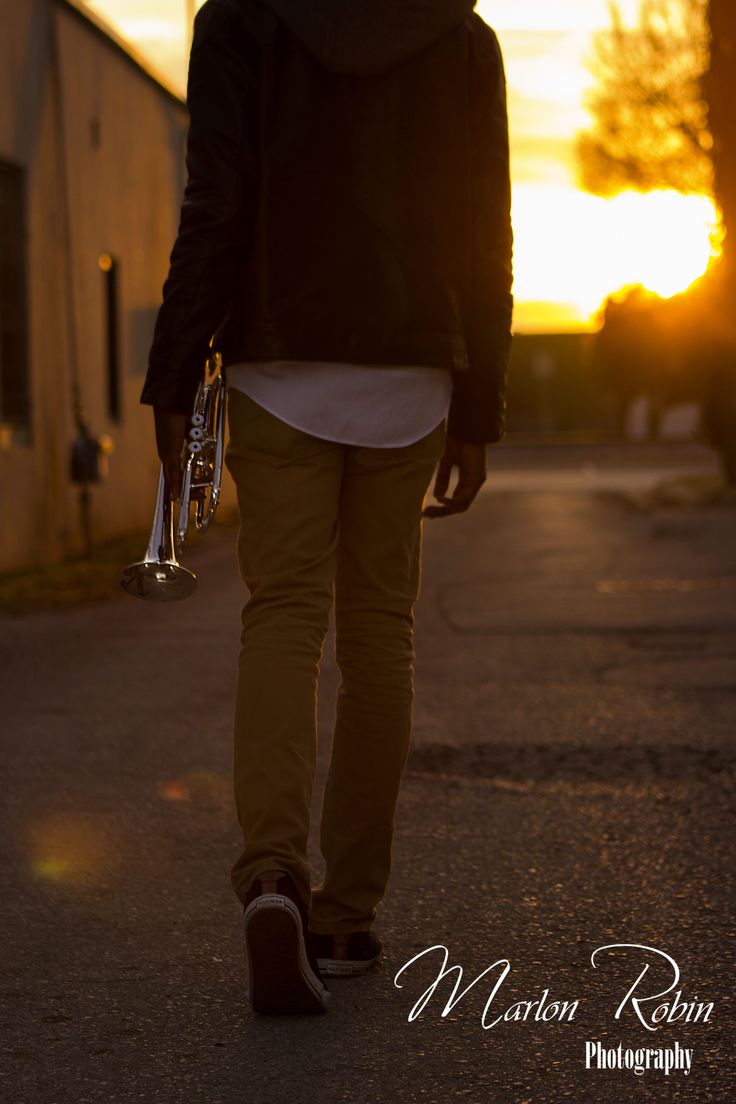 a man walking down the street with his wine glass in hand at sunset or dawn