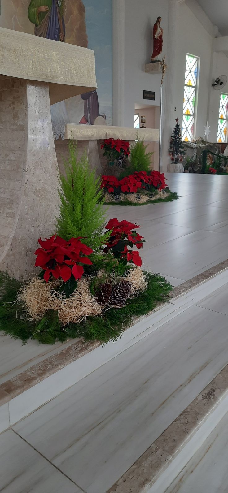 the interior of a church decorated with poinsettis and greenery for christmas