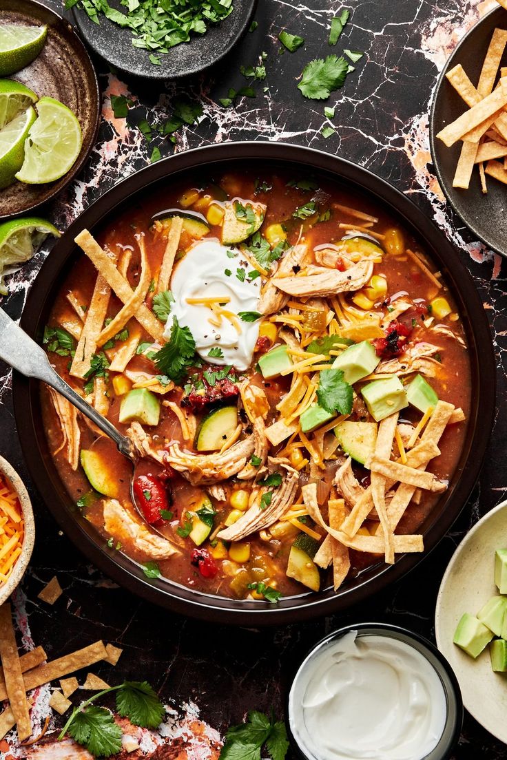 a bowl of mexican chicken tortilla soup with sour cream