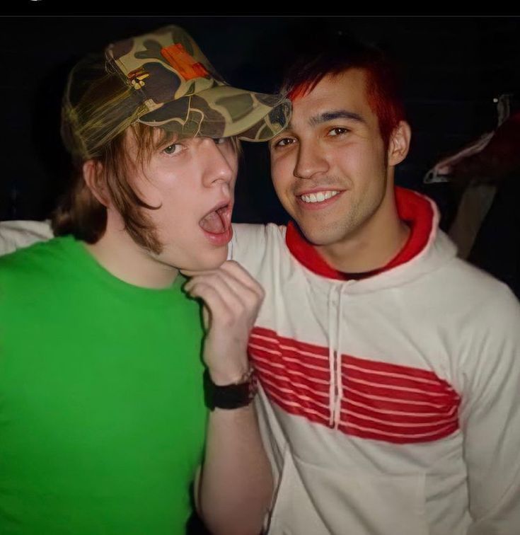 two young men posing for the camera with one holding his tongue out and another making a funny face