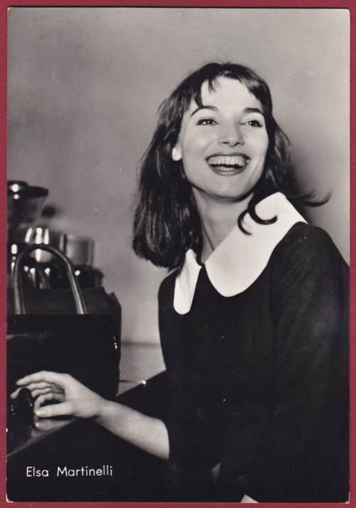 black and white photograph of a woman sitting at a table with a coffee maker in front of her