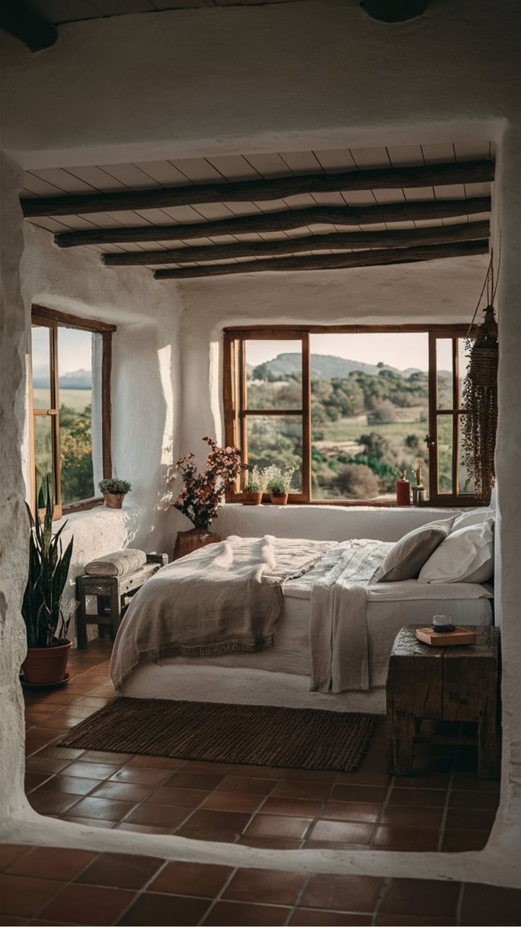 a bed sitting inside of a bedroom on top of a wooden floor next to a window