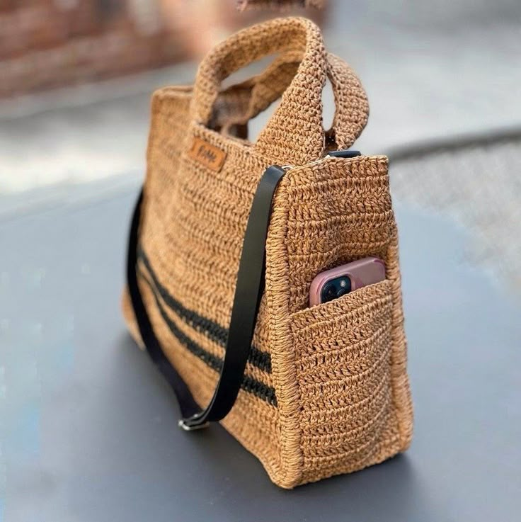 a straw bag with an iphone in it