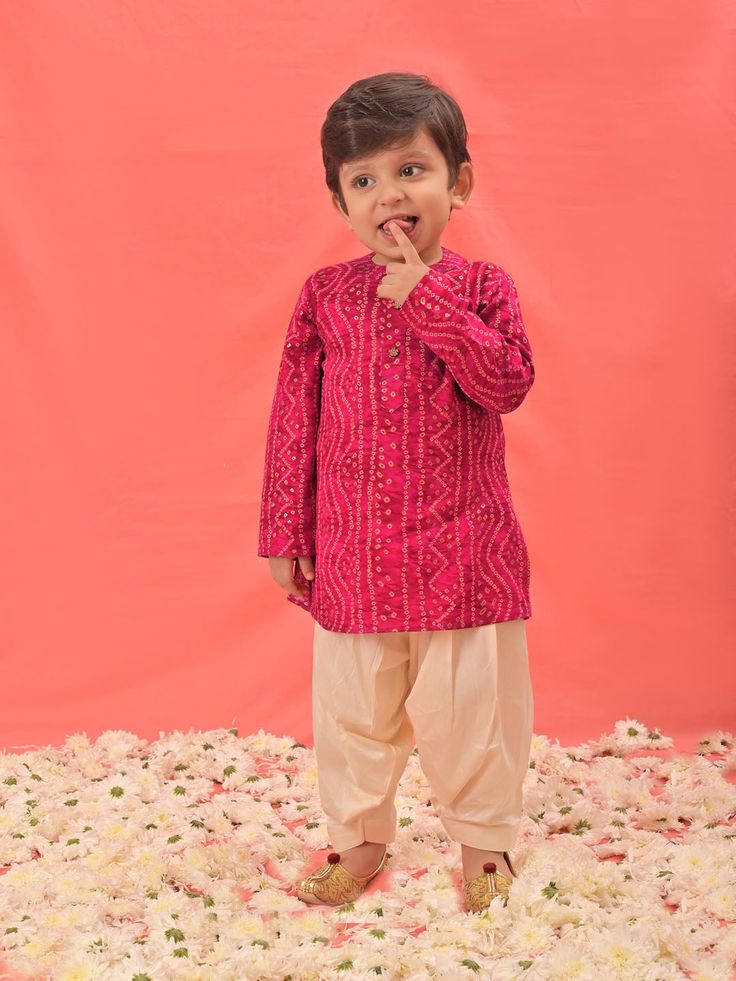 VASTRAMAY SISHU Boys' Pink Bandhni Kurta And Patiala Set Dress your little one in style and tradition with this vibrant pink kurta patiala set. Featuring a beautiful bandhani print, the kurta boasts a comfortable relaxed fit and a mandarin collar. The set comes complete with cream colored patiala pants for a complete and festive look. Key Features Pink Bandhni Print Mandarin Collar Kurta Relaxed Fit Cream Patiala Pants Elasticated Waistband for Comfort Specifications Material: Kurta - Rayon, Pat Navratri Pink Kurta With Traditional Drape, Pink Kurta With Zari Work For Transitional Season, Long Sleeve Pink Kurta With Gota Work, Pink Straight Kurta Choli For Diwali, Pink Kurta With Chikankari Embroidery For Transitional Season, Diwali Pink Straight Kurta Choli, Transitional Pink Kurta With Chikankari Embroidery, Pink Long Sleeve Sherwani With Dabka, Transitional Season Pink Straight Kurta