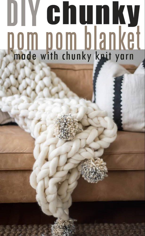 the chunky pom pom blanket made with chunk knit yarn is shown on a couch