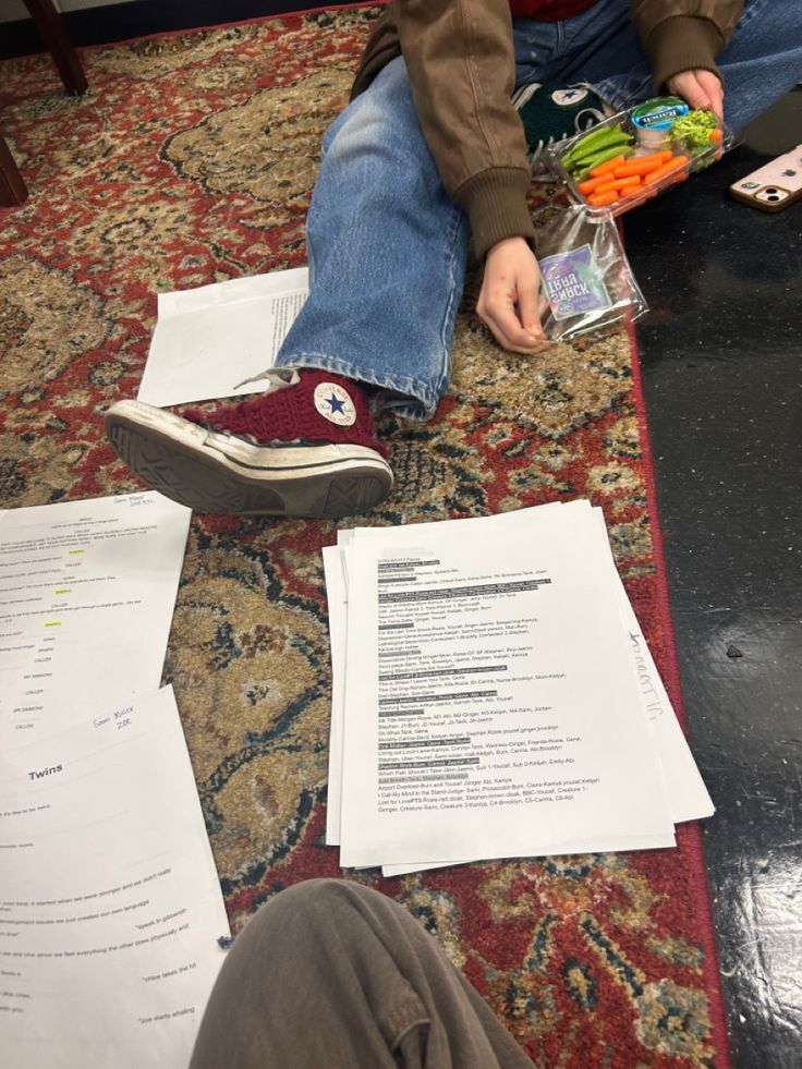 a person sitting on the floor with some papers