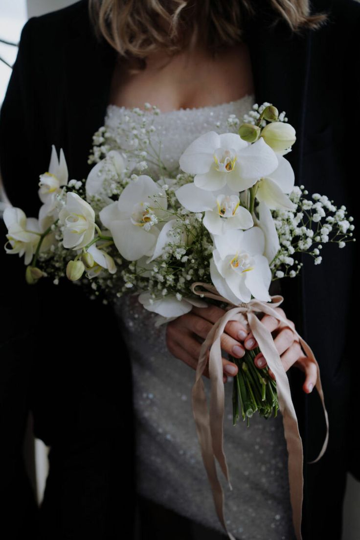 a woman holding a bouquet of white flowers