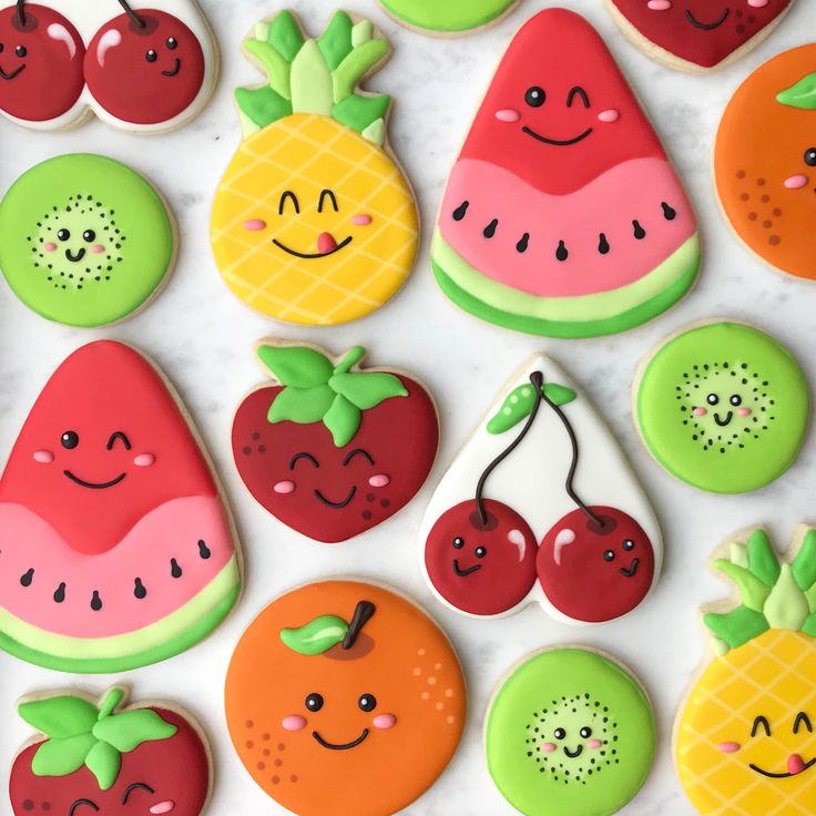 decorated cookies are arranged in the shape of fruits