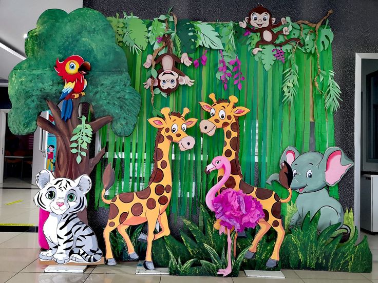 there are many different animals on display in front of a wall with plants and trees