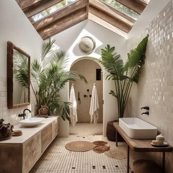 a large bathroom with two sinks and plants in the shower area, along with a skylight