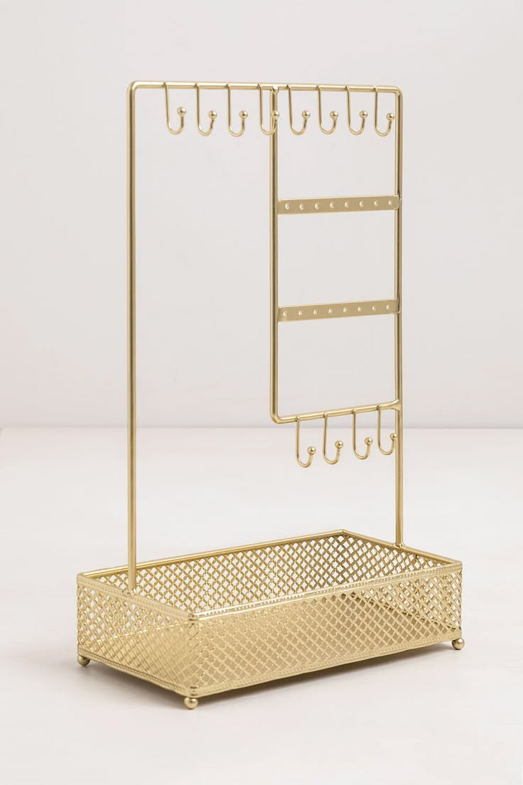 a gold metal shelf with hooks on the bottom and two rows of hooks attached to it