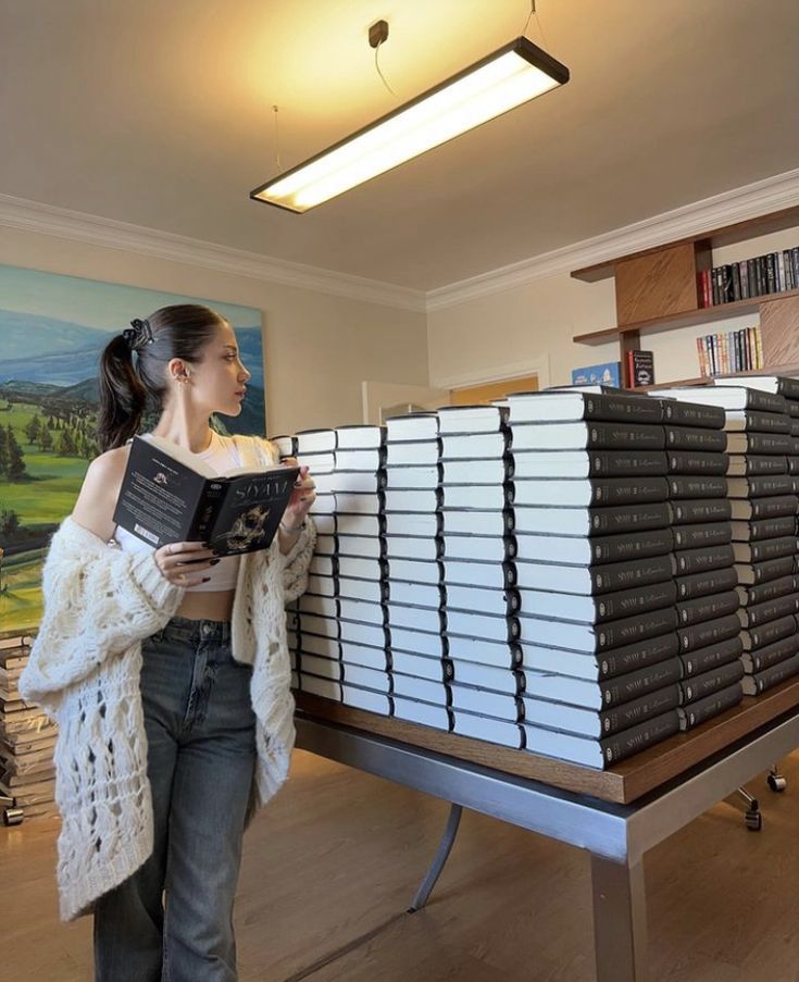 a woman standing in front of stacks of books