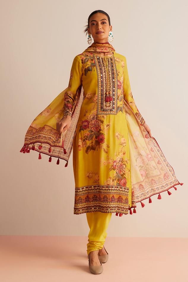 Yellow straight kurta with floral print, highlighted with mirror work and tassels. Paired with a churidar and dupatta.
Components: 3
Pattern: Print
Type Of Work: Floral
Neckline: Round Neck
Sleeve Type: Full Sleeves
Fabric: Cotton Silk
Color: Yellow
Other Details: 
Model height:  5 ft 9 inches, wearing size S
Length:
Kurta Length - 46 inches
Churidar Length - 55 inches
Floral print dupatta with tassels
Occasion: Puja - Aza Fashions Kurta Set For Women, Straight Kurta, Mirror Work, Churidar, Kurta Set, Full Sleeves, Set For Women, Cotton Silk, Aza Fashion