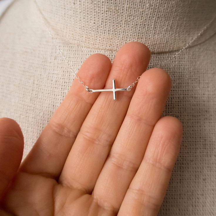 "Sterling Silver Sideways Cross Necklace Dainty and minimalist sideways cross necklace. Lightweight, perfect for everyday wear. Wear it as a choker, or choose a longer chain for a classic look. FEATURES: * dainty cross hangs in the middle of the necklace, * comes on a delicate flat cable chain, finished with a spring clasp closure. MEASUREMENTS: * sterling silver cross is 6/8\" wide and 3/8\" high (19x10 mm) * sterling silver cable chain is 1.4 mm wide * the necklace shown on a life size mannequ Minimalist Cross Pendant Necklace For Everyday, Minimalist Cross Pendant Necklace For Everyday Wear, Everyday Cross Necklace With Clavicle Chain, Everyday Clavicle Chain Cross Necklace, Minimalist Clavicle Cross Chain Jewelry, Minimalist Cross Necklace For Everyday, Simple Everyday Cross Jewelry, Minimalist Sterling Silver Cross Necklace With Clavicle Chain, Silver Minimalist Cross Necklace With Clavicle Chain